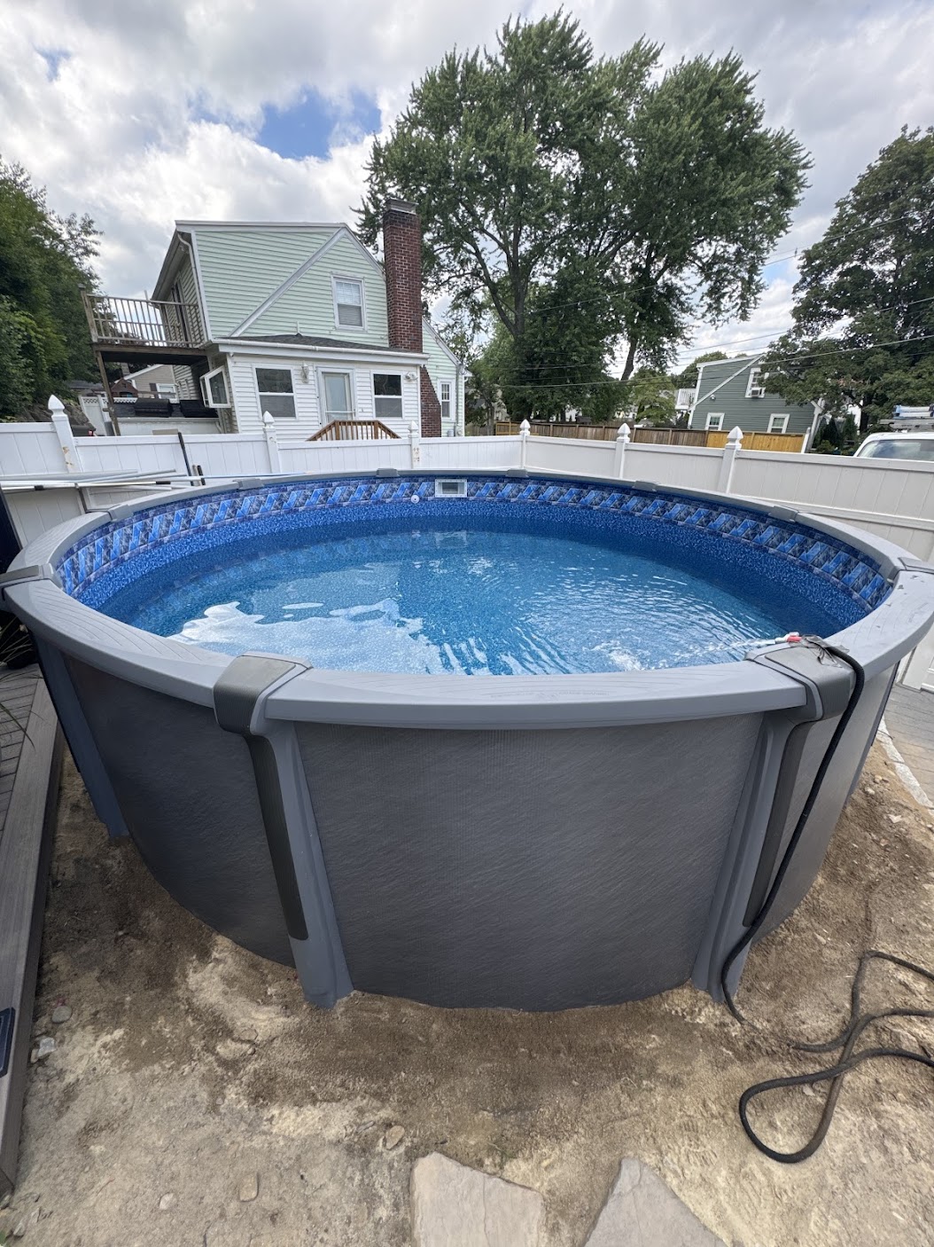 Round above-ground pool installation in a Massachusetts backyard by North Shore Pool Boys