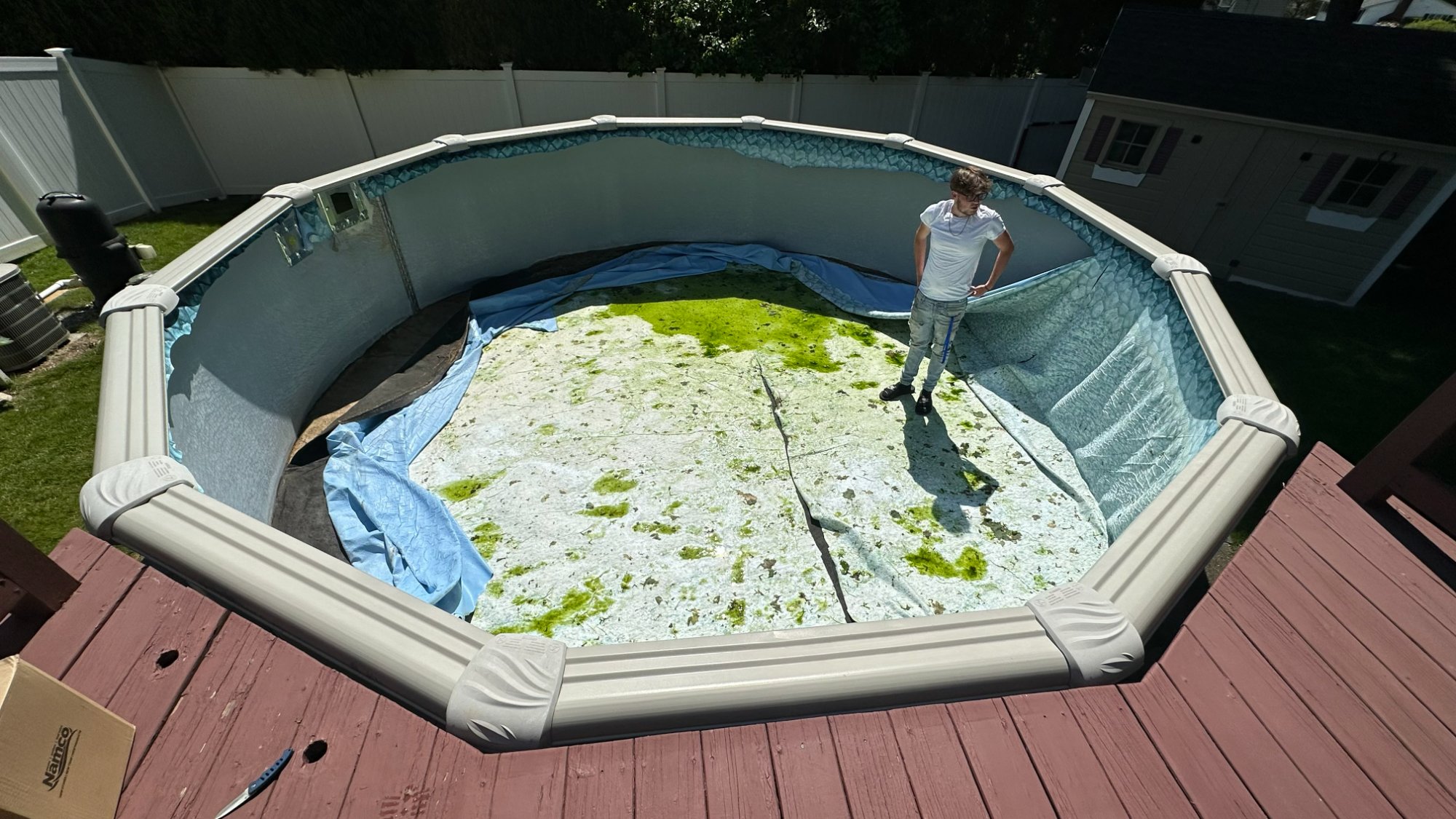 Above-ground pool before liner replacement — old damaged liner with algae buildup